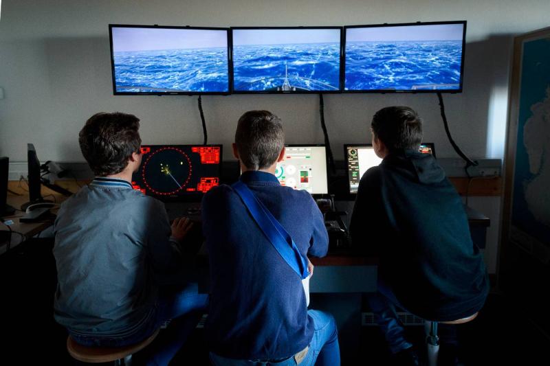 3 élèves devant un simulateur de navigation