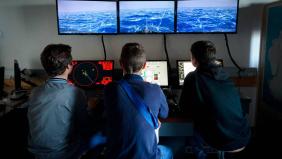3 élèves devant un simulateur de navigation